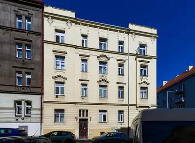 a large white building with cars parked in front of it at Comfortable apartment in Prague 8 - Libeň in Prague