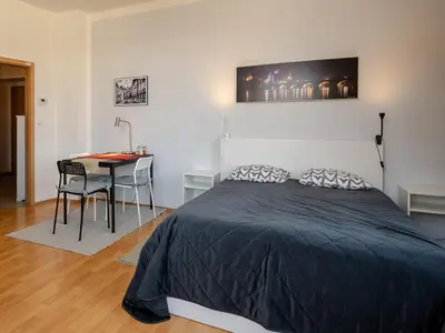 a bedroom with a bed and a desk and a table with chairs at Comfortable apartment in Prague 8 - Libeň in Prague
