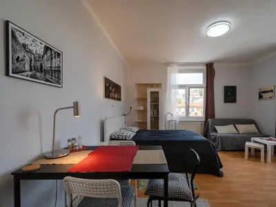 a bedroom with a bed and a table and chairs at Comfortable apartment in Prague 8 - Libeň in Prague
