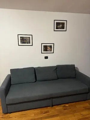 a couch in a living room with three pictures on the wall at Cool Duplex with terrace near Florenc in Prague