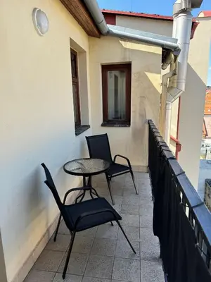 a patio with two chairs and a table on a balcony at Cool Duplex with terrace near Florenc in Prague