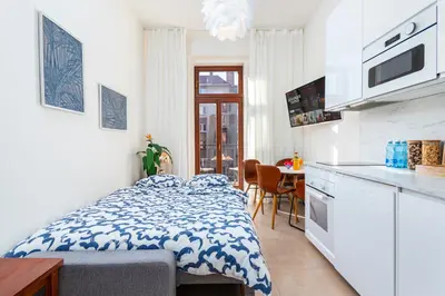 a bedroom with a bed and a table and a window at Central Cozy Gateway in Prague