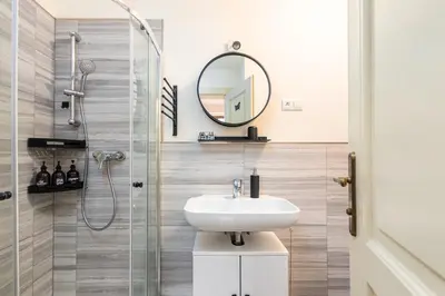 a bathroom with a sink and a shower with a mirror at Central Cozy Gateway in Prague