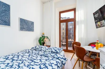 a white bedroom with a bed with a yellow blanket at Central Cozy Gateway in Prague