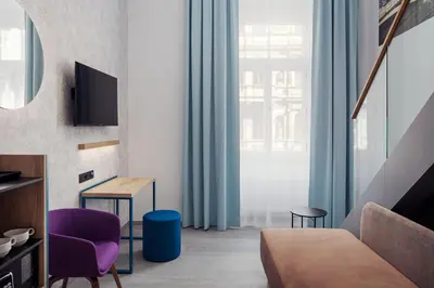 a living room with a couch and a purple chair at EA Hotel Moment Self Check-In in Prague