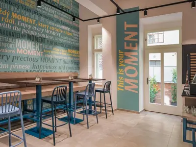 a restaurant with a long table and chairs at EA Hotel Moment Self Check-In in Prague