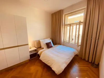 a small bedroom with a bed and a window at Modern Apartments Letna in Prague