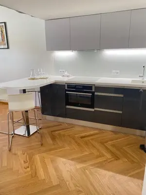 a kitchen with black and white counters and a wooden floor at Modern Apartments Letna in Prague