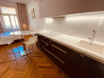 a kitchen with a sink and a counter with a table at Modern Apartments Letna in Prague