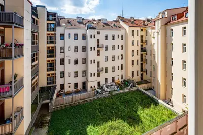 an apartment with a green yard in the middle of buildings at Great apartment in the hype neighborhood in Prague