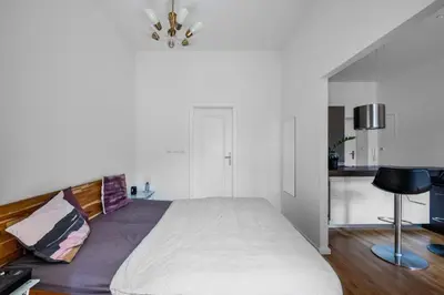 a bedroom with a large bed and a kitchen at Great apartment in the hype neighborhood in Prague