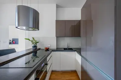 a kitchen with white cabinets and a black counter top at Great apartment in the hype neighborhood in Prague