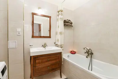 a bathroom with a sink and a tub and a mirror at Vinohrady Retreat 2BDR Central in Prague