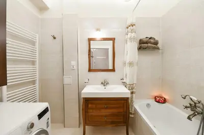 a bathroom with a tub and a sink and a bath tub at Vinohrady Retreat 2BDR Central in Prague