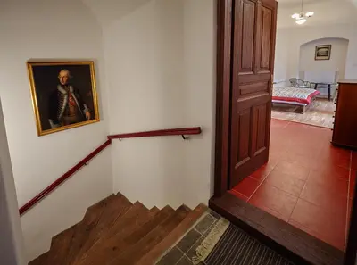 a hallway with a painting of a man on a wall at Queen Bee apartments in Prague