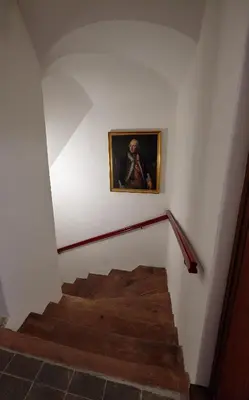 a stairway with a painting of a man on the wall at Queen Bee apartments in Prague