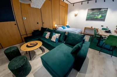 a living room with a green couch and a table at Riverside Hideout in Prague