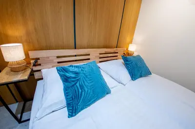 a bed with two blue pillows on top of it at Riverside Hideout in Prague