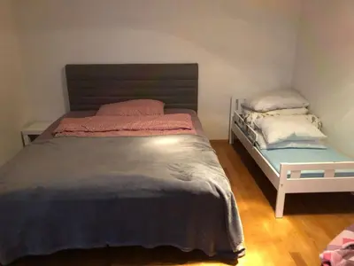 a bedroom with a large bed and a bench at Prostorný byt 3kk s krásnou terasou a vnitřním parkem in Prague
