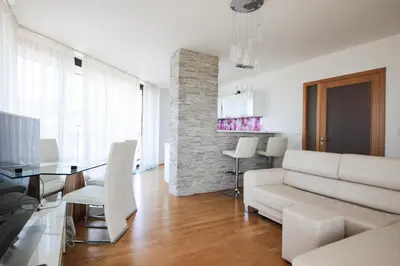 a living room with a white couch and a table at Prostorný byt 3kk s krásnou terasou a vnitřním parkem in Prague