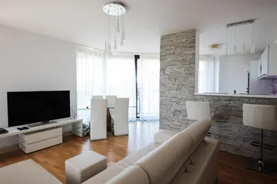 a living room with a couch and a flat screen tv at Prostorný byt 3kk s krásnou terasou a vnitřním parkem in Prague