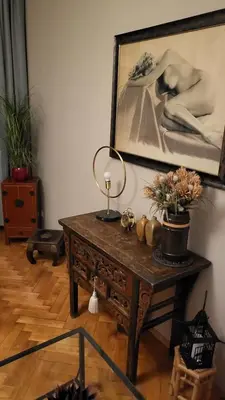 a table with a lamp and a painting on the wall at Premium Apt - Free Massages from Physiotherapists in Prague