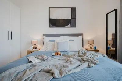 a dog laying on a bed with a blanket at Prague Days - Apartments with Garage and Balcony Near City Center in Prague