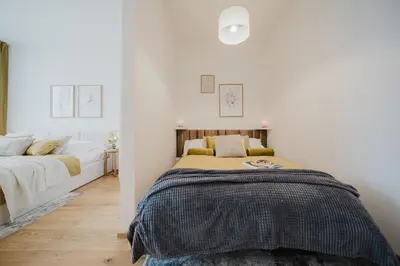 a bedroom with a bed in a room with white walls at Prague Days - Apartments with Garage and Balcony Near City Center in Prague