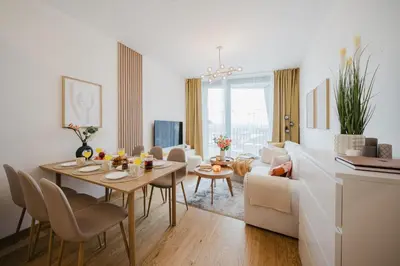 a white living room with a table and a couch at Prague Days - Apartments with Garage and Balcony Near City Center in Prague