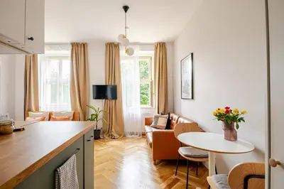 a kitchen and living room with a table and a living room at Quiet Warm studio, 5 min to Metro A, airport link, fast Wi-Fi in Prague