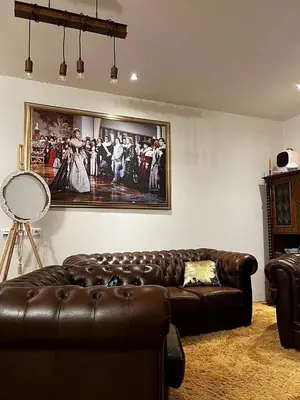 a living room with a leather couch and a painting at Luxe-Boutique Apartments in Prague