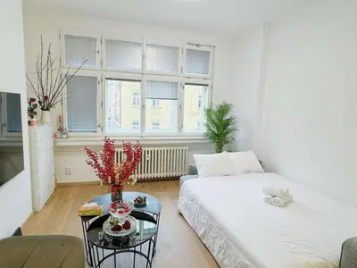 a living room with a bed and a table at Cozy Nest Home in Prague