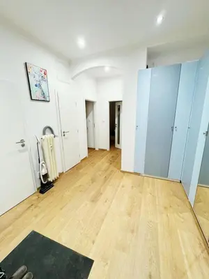 an empty room with white cabinets and a wooden floor at Cozy Nest Home in Prague