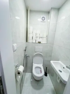 a white bathroom with a toilet and a sink at Cozy Nest Home in Prague
