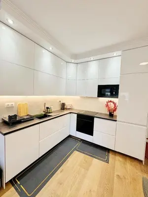 a large white kitchen with white cabinets and appliances at Cozy Nest Home in Prague