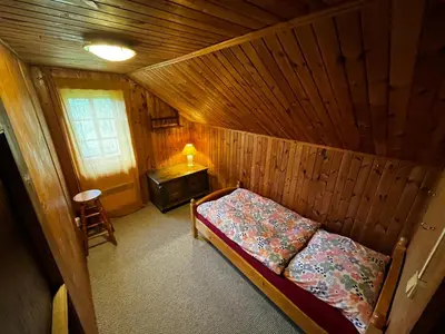 a bedroom with a bed in a wooden cabin at Chalupa Na Vyhlídce in Sudoměř