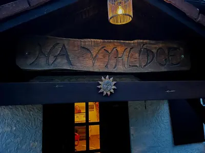 a sign on the front of a building with graffiti at Chalupa Na Vyhlídce in Sudoměř