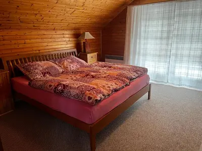 a bedroom with a bed with a wooden wall at Chalupa Na Vyhlídce in Sudoměř