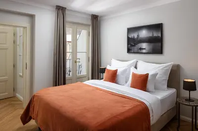 a bedroom with a large bed with orange and white pillows at The Bridge Residence by Little King in Prague
