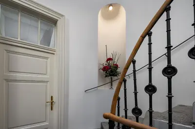 a stairway with a door and a vase of flowers at The Bridge Residence by Little King in Prague