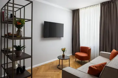 a living room with a couch and a tv on a wall at The Bridge Residence by Little King in Prague