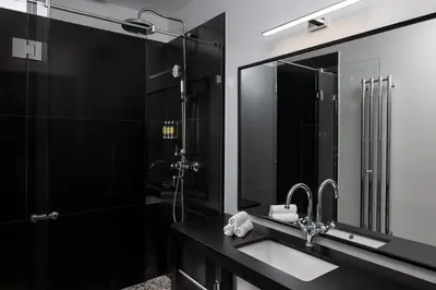 a black bathroom with a sink and a shower at The Bridge Residence by Little King in Prague