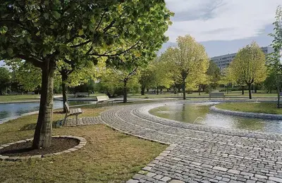 a park with a tree and a stone walk way at Large apartment Prosek - Your second home! in Prague