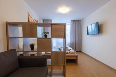 a living room with a book shelf and a couch at Large apartment Prosek - Your second home! in Prague