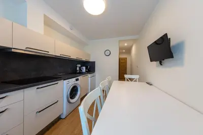 a kitchen with a table and a laundry room at Large apartment Prosek - Your second home! in Prague