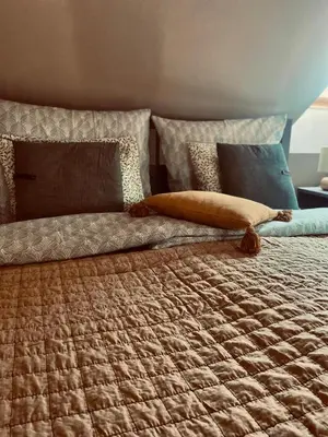 a bed with a blanket and pillows on it at Penzion Patina House Barevný Svět in Mníšek pod Brdy
