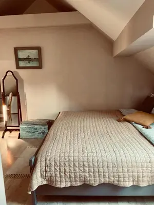 a bedroom with a bed and a chair at Penzion Patina House Barevný Svět in Mníšek pod Brdy