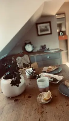 a wooden table with dishes and a plant on it at Penzion Patina House Barevný Svět in Mníšek pod Brdy