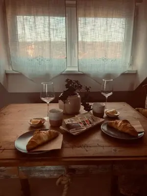 a wooden table with bread and glasses of wine at Penzion Patina House Barevný Svět in Mníšek pod Brdy
