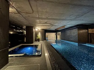 a large swimming pool with a hot tub in a building at Luxe studio with pool, sauna, jacuzzi, gym, balcony in Prague